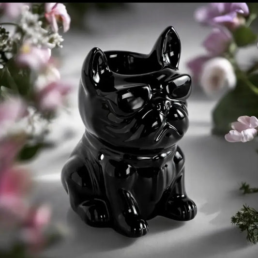 Brûle-parfum en céramique noire laquée en forme de bouledogue français avec lunettes, modèle Boubou Noir devant un feu de cheminée