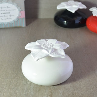 Diffuseur de parfum par capillarité Narcisse Blanc, fleur en plâtre poreux sur socle en céramique blanche.