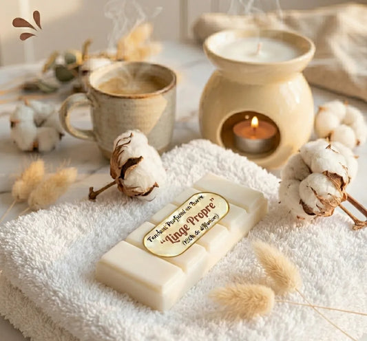 Fondant parfumé en barre senteur Linge Propre des Fées Mères, posé sur une serviette blanche avec des fleurs de coton, boutique KAVERN.