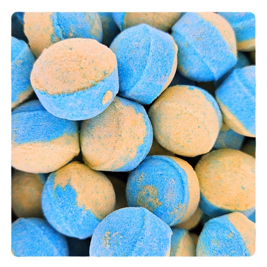 Mini-billes effervescentes bicolores bleu et jaune pour le bain, au parfum romantique In Love. Un soin ludique et original de la boutique KAVERN.