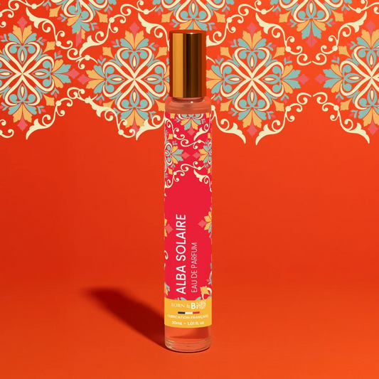 Eau de Parfum Alba Solaire Born to Bio sur un fond rouge orangé aux élégants motifs floraux. Pyramide olfactive rayonnante : Vanille, Néroli et Fleur d'Oranger.