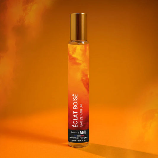 Eau de Parfum Éclat Boisé Born to Bio dans une ambiance incandescente. Pyramide olfactive vibrante : Bergamote, Vétiver et Lavande.