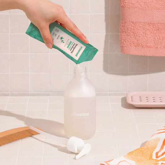 Préparation de l'éco-recharge Pimpant : versez la poudre de shampoing purifiant dans votre flacon en verre et ajoutez de l'eau tiède.
